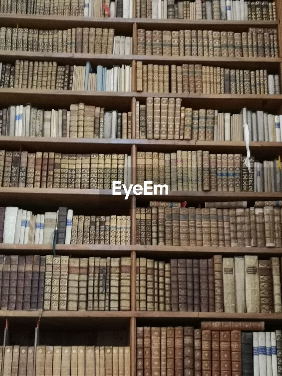 FULL FRAME SHOT OF BOOKS IN SHELF AT LIBRARY