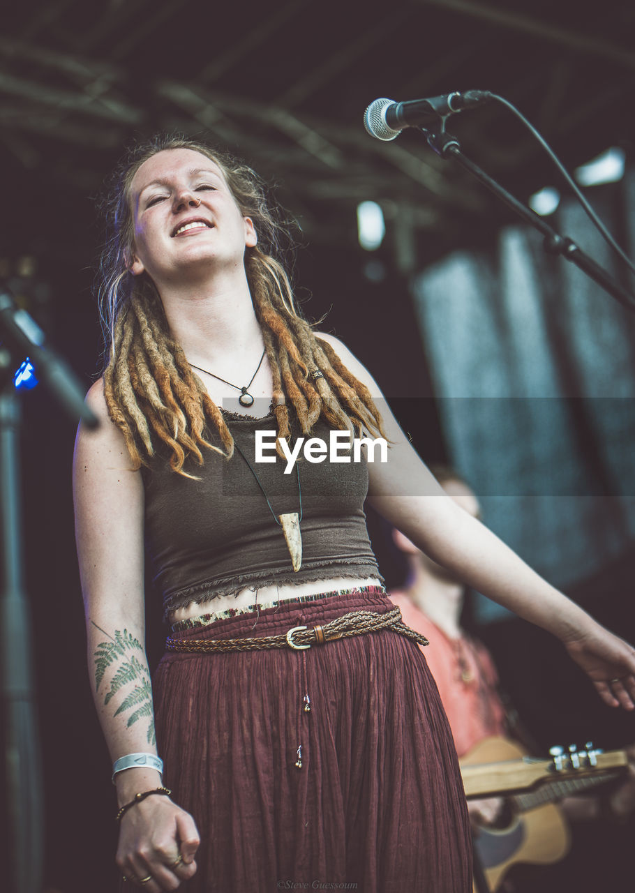Low angle view of singer with dreadlocks singing on stage