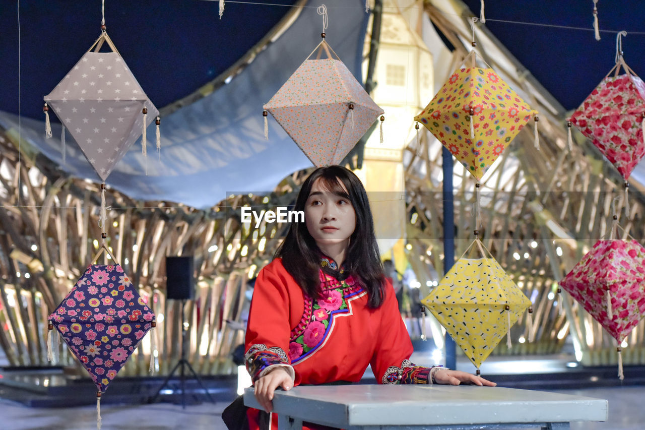 PORTRAIT OF YOUNG WOMAN STANDING WITH UMBRELLA