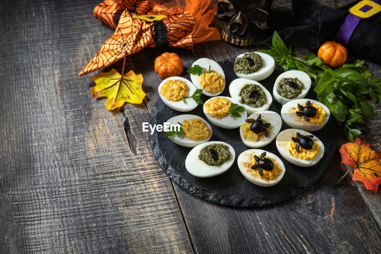 Halloween funny idea for party food. halloween creative set stuffed eggs on a wooden table.