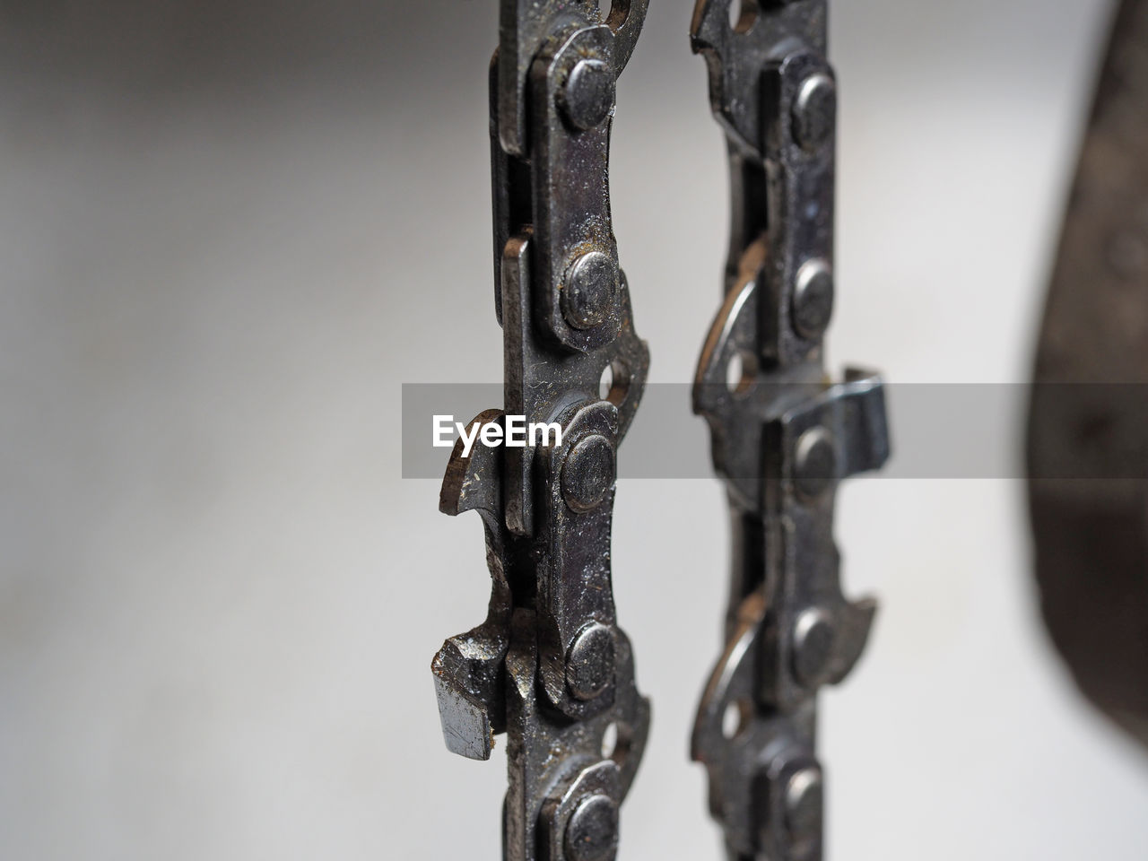CLOSE-UP OF RUSTY CHAIN HANGING AGAINST WALL
