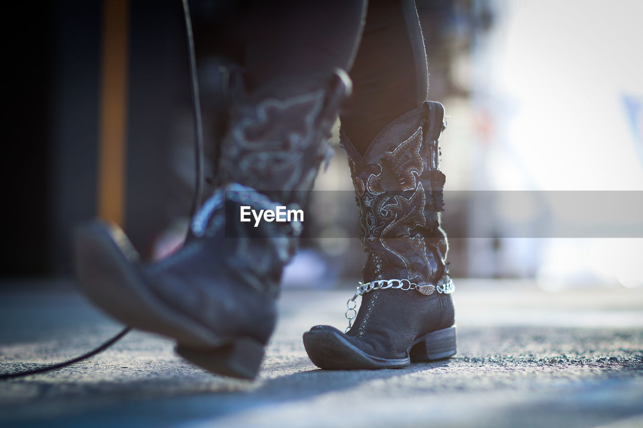 Low section of woman wearing cowboy boots