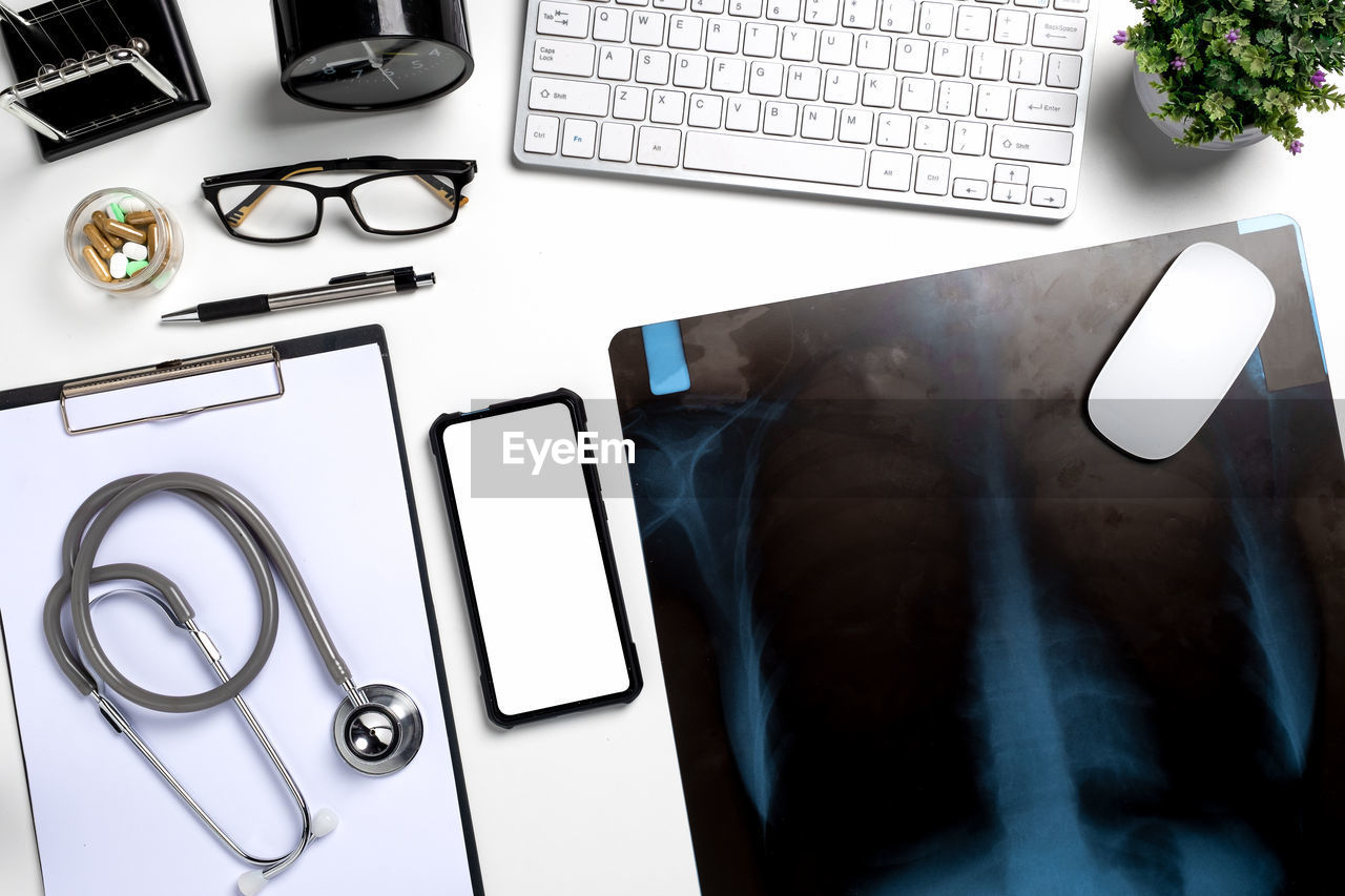 HIGH ANGLE VIEW OF SMART PHONE ON TABLE AND LAPTOP