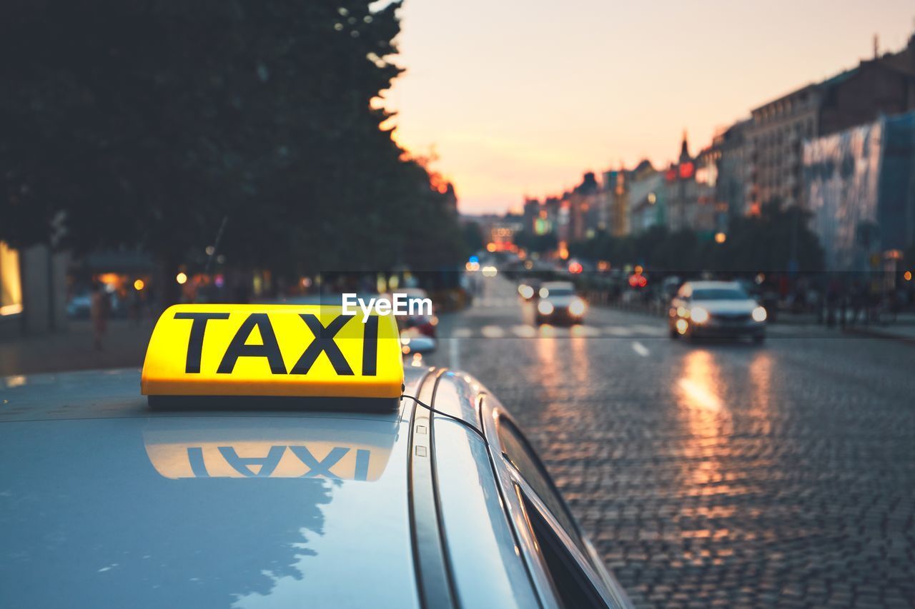 Close-up of taxi on road against sky