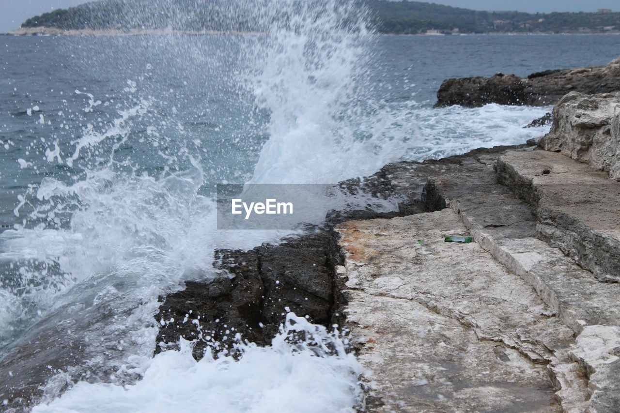 WAVES SPLASHING ON ROCKY SHORE