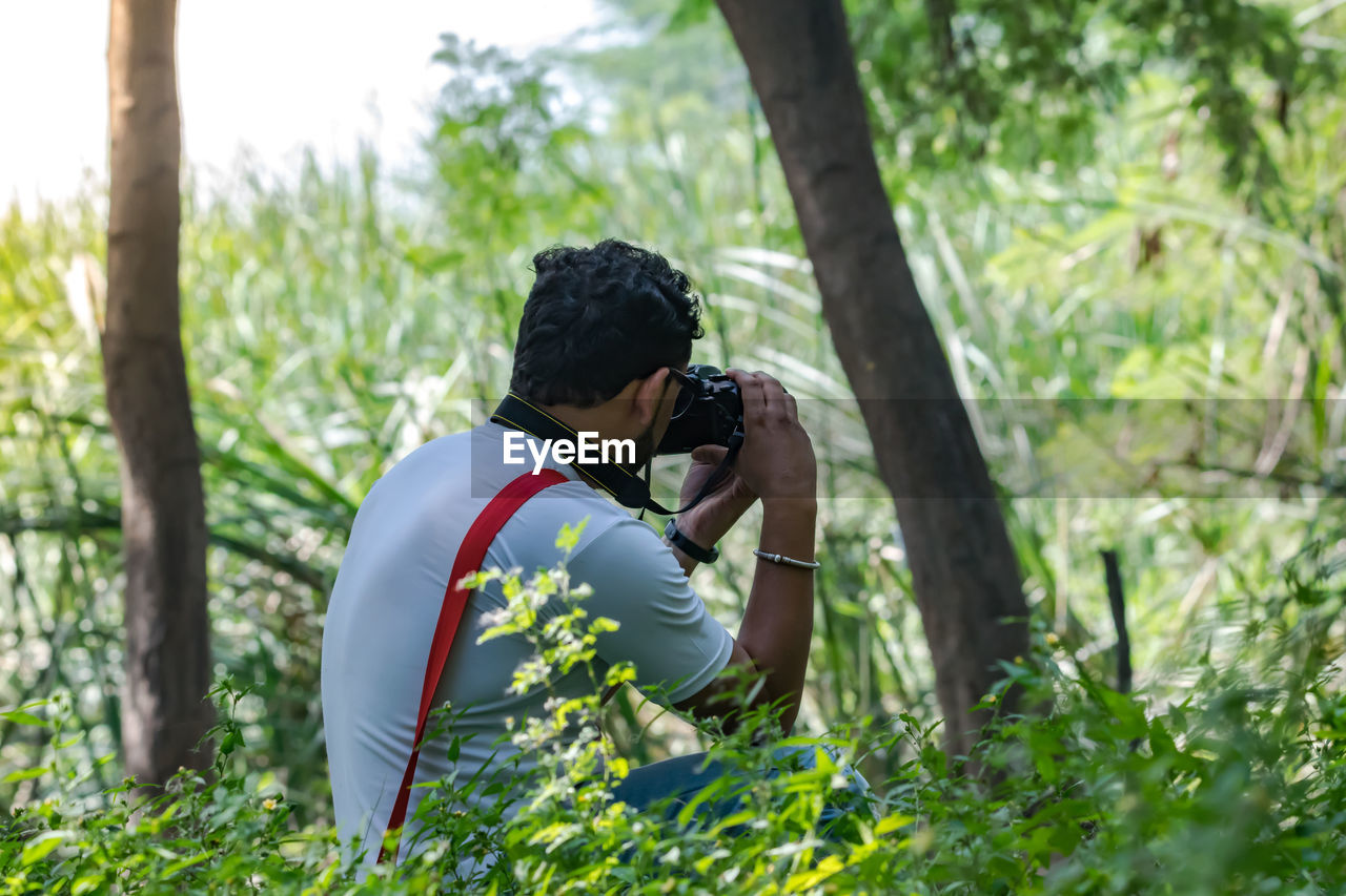 Man photographing in forest