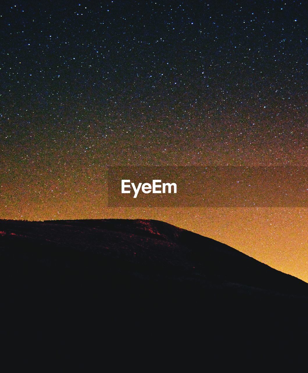 Scenic view of silhouette mountain against star field at night