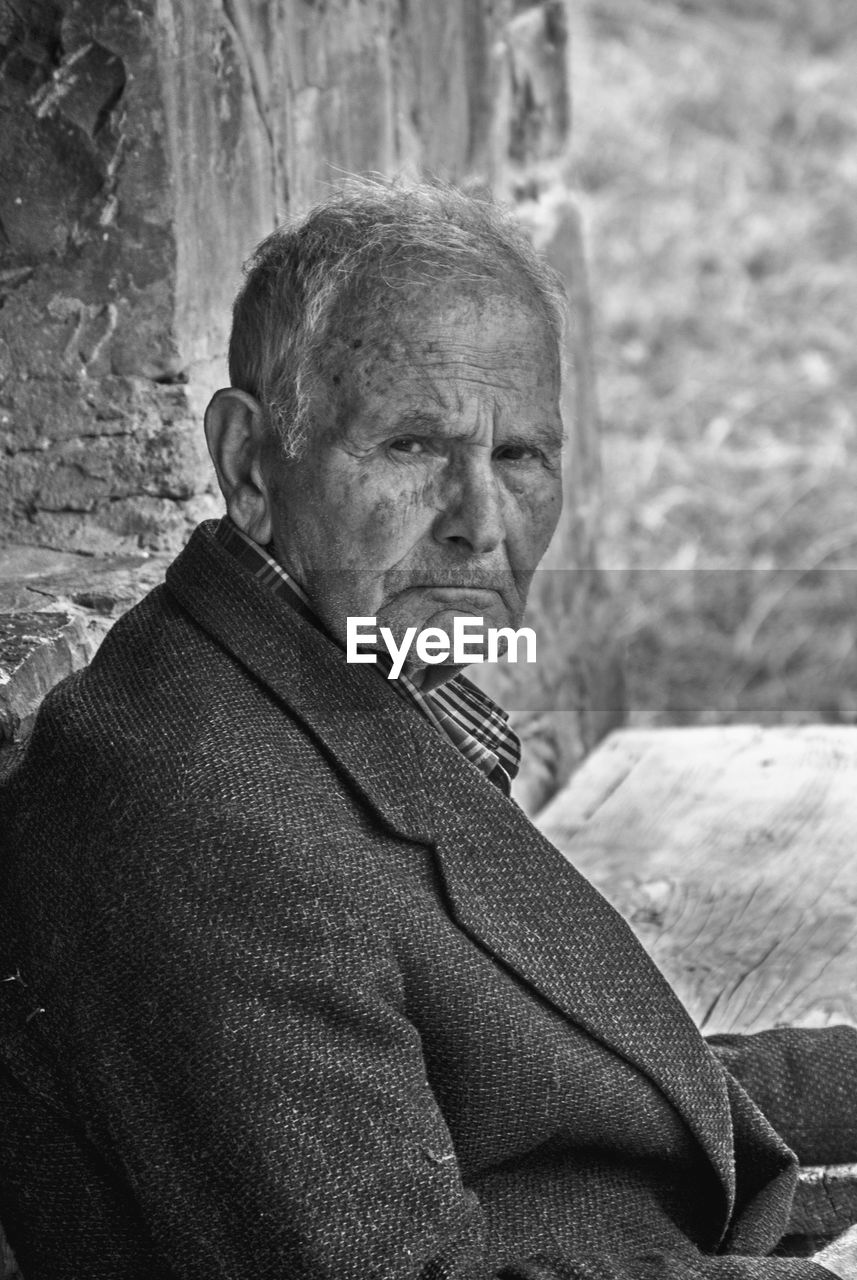 Close-up portrait of senior man sitting outdoors