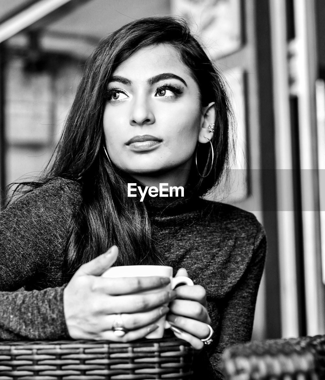 Thoughtful young woman holding coffee cup