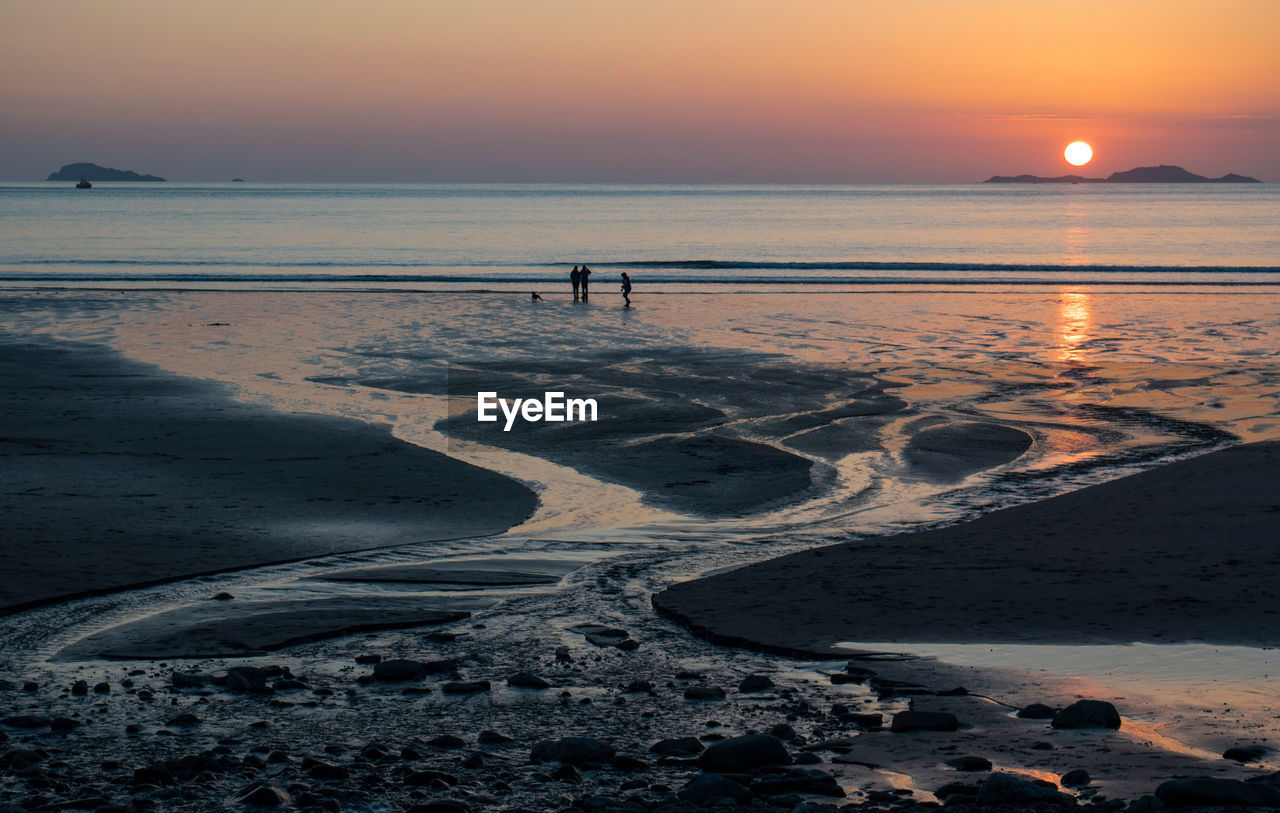 SCENIC VIEW OF BEACH DURING SUNSET