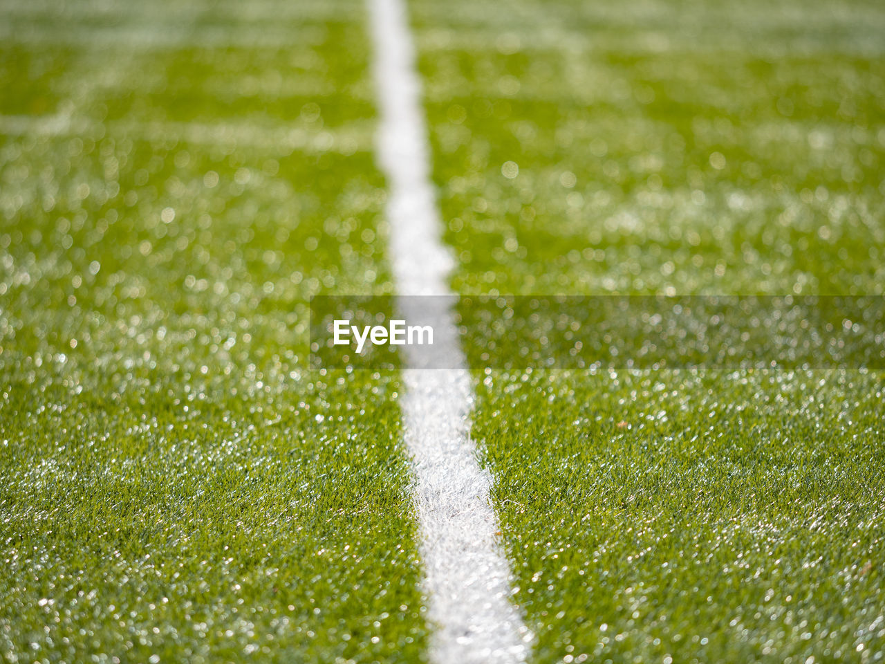 Detailed lines on soccer football field. sun makes reflection in plastic material