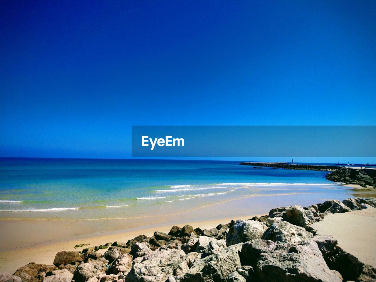 Scenic view of sea against clear blue sky