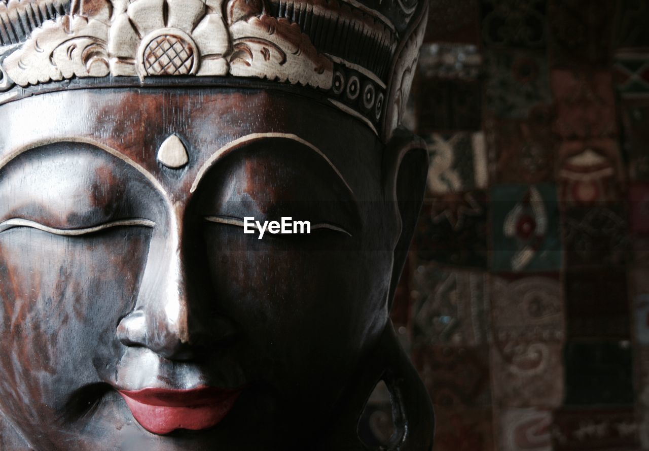 Close-up of buddha statue against building