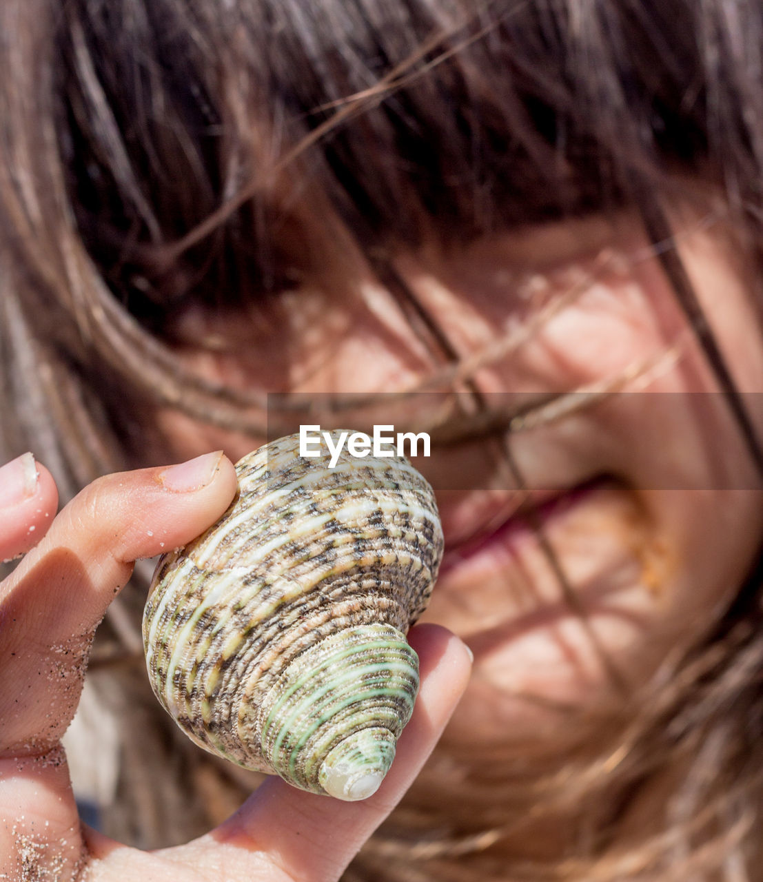 CLOSE-UP OF WOMAN HOLDING SHELLS