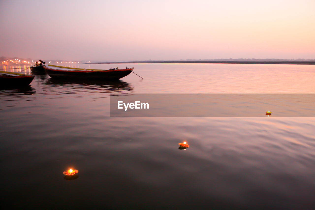 High angle view of illuminated diyas on ganges river during sunrise