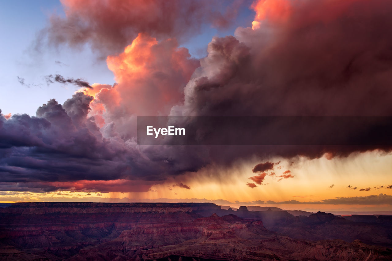 Sunset light illuminates dramatic clouds as a monsoon thunderstorm builds over the grand canyon.