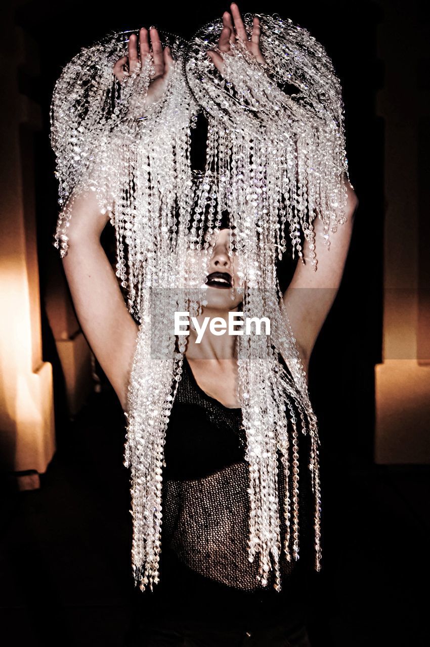 Sensuous young woman holding glittering decorations