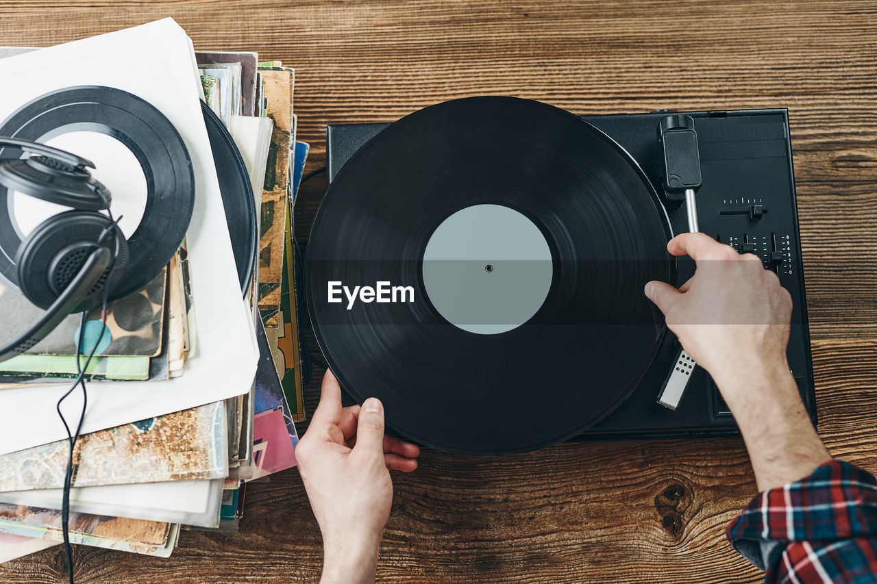 Man listening to music from vinyl record. playing music from analog disk on turntable player. hobby