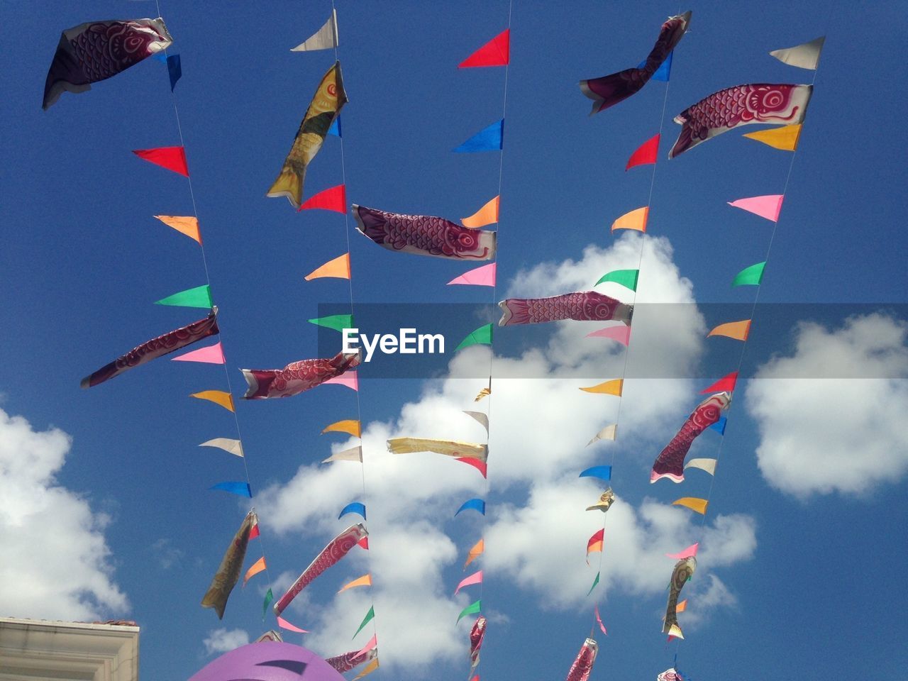 Low angle view of flags against cloudy sky