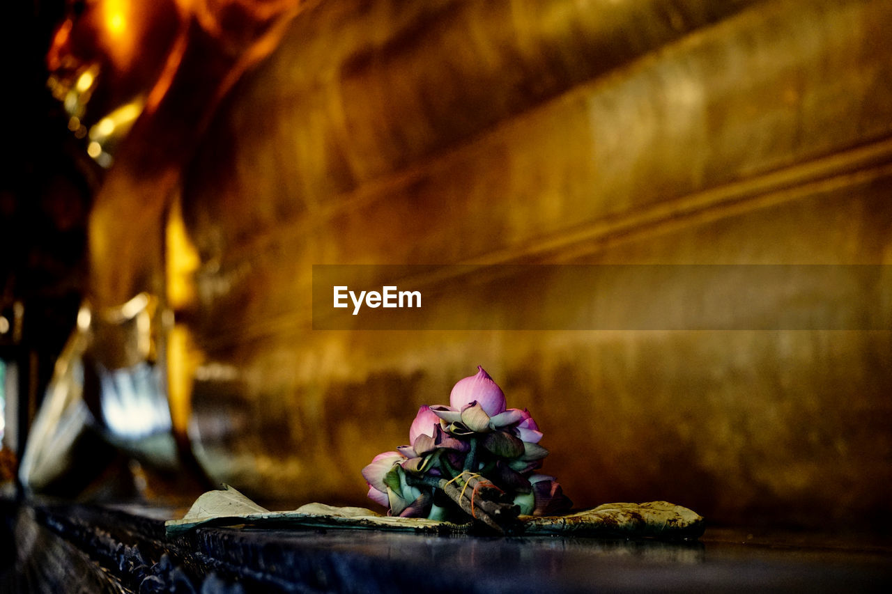 CLOSE-UP OF FLOWER STATUE ON TABLE AT TEMPLE