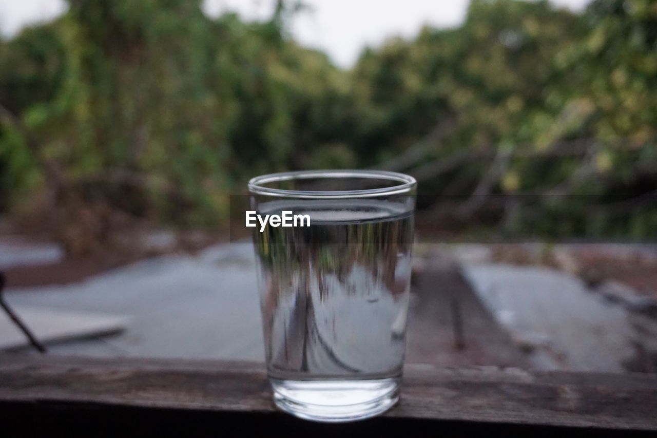 CLOSE-UP OF DRINK IN GLASS ON WATER