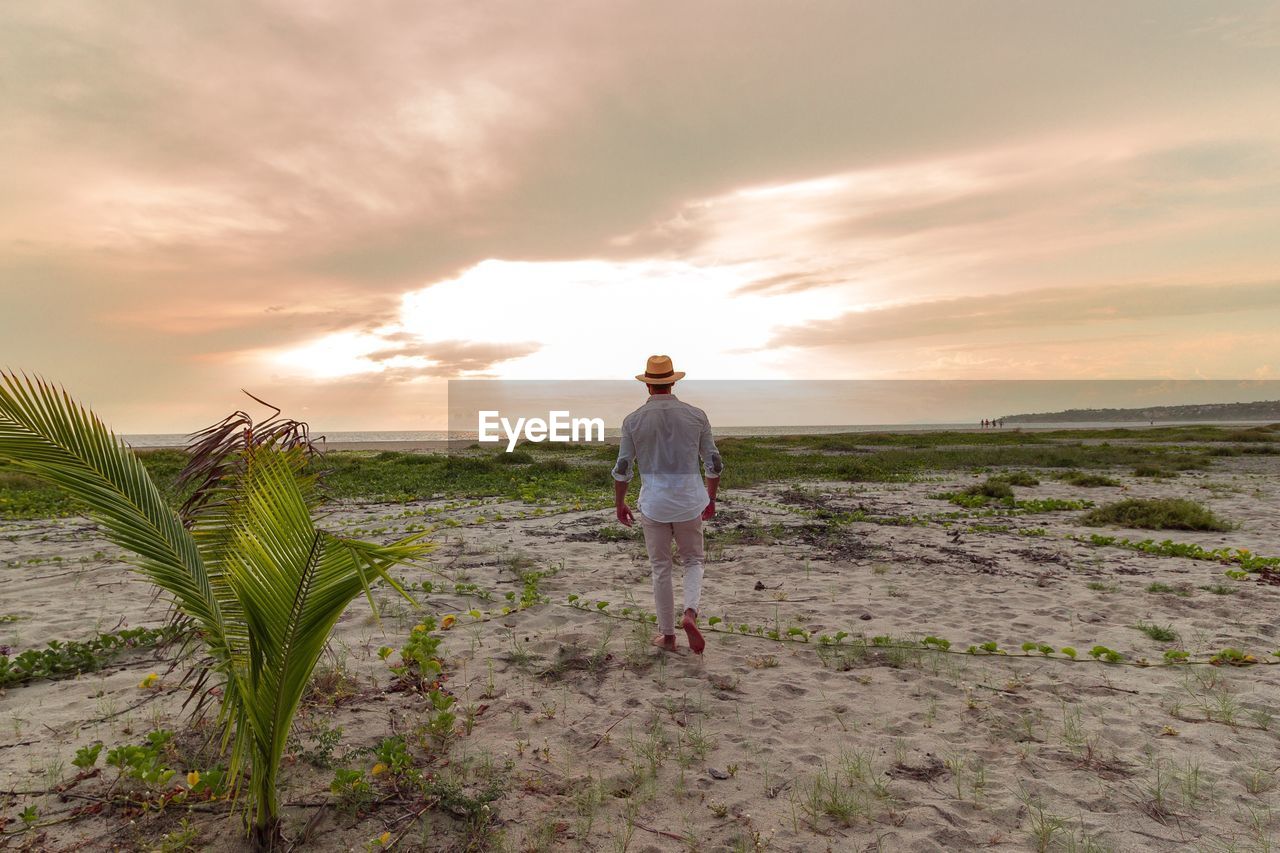 FULL LENGTH OF MAN STANDING ON LAND AGAINST SKY