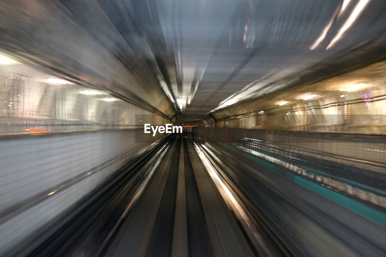 BLURRED MOTION OF SUBWAY TRAIN AT ILLUMINATED RAILROAD STATION