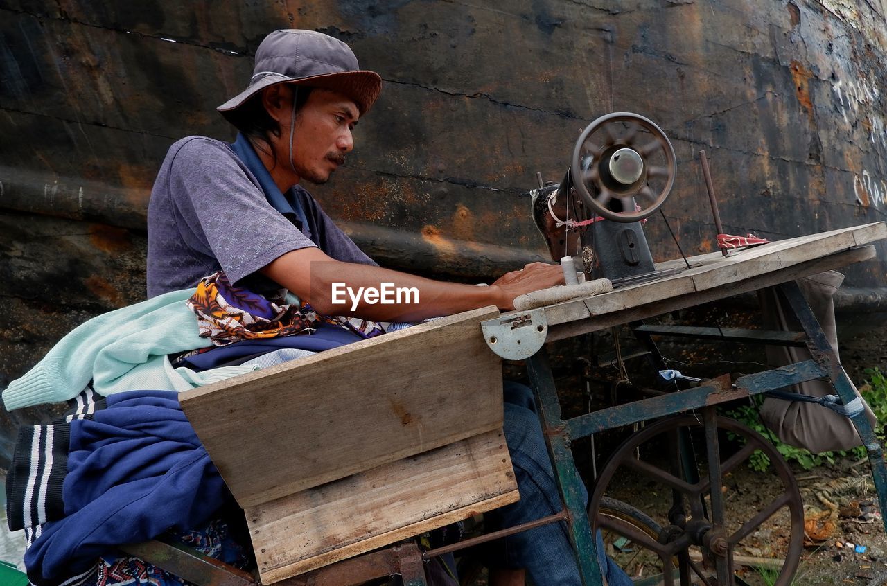 FULL LENGTH OF MAN WORKING ON METAL STRUCTURE