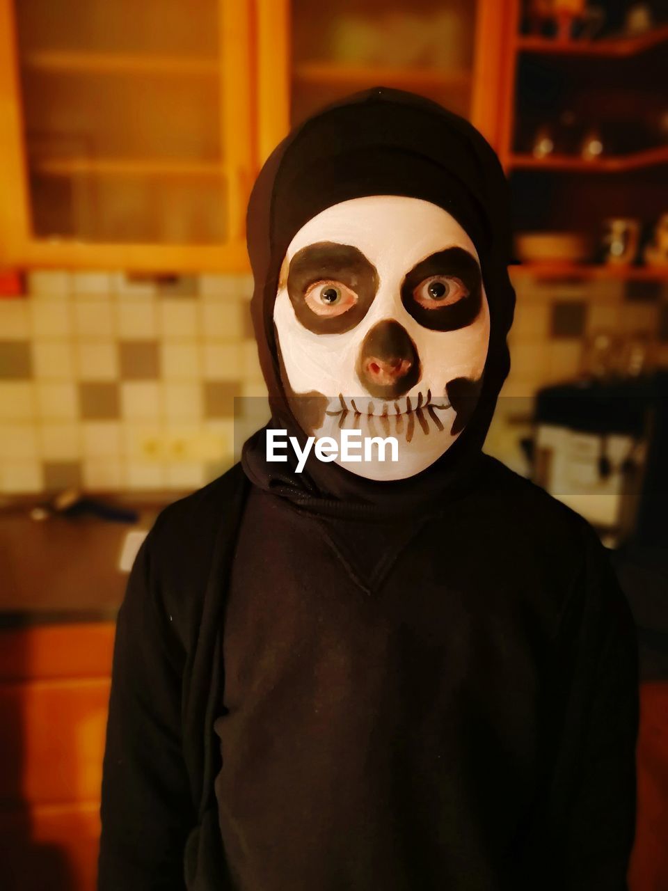 Portrait of boy with spooky face paint at home during halloween