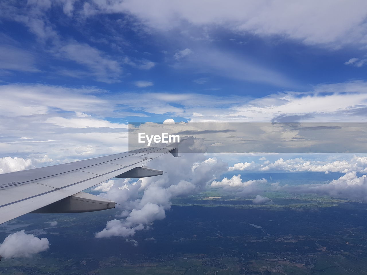 Aircraft wing flying in cloudy sky