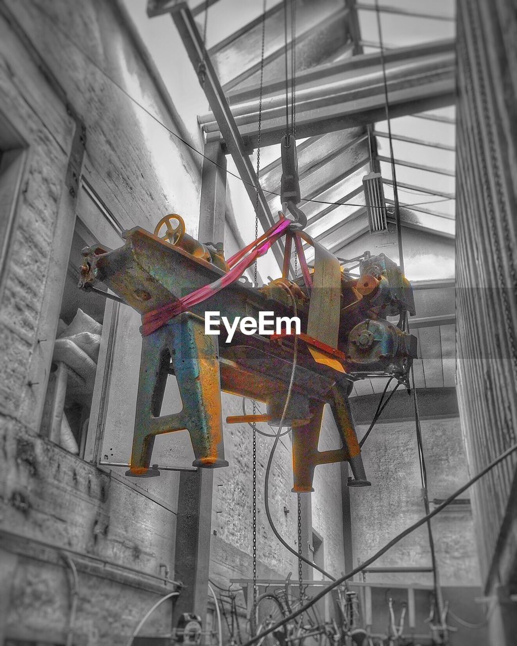 Low angle view of machinery hanging on crane hook at construction site