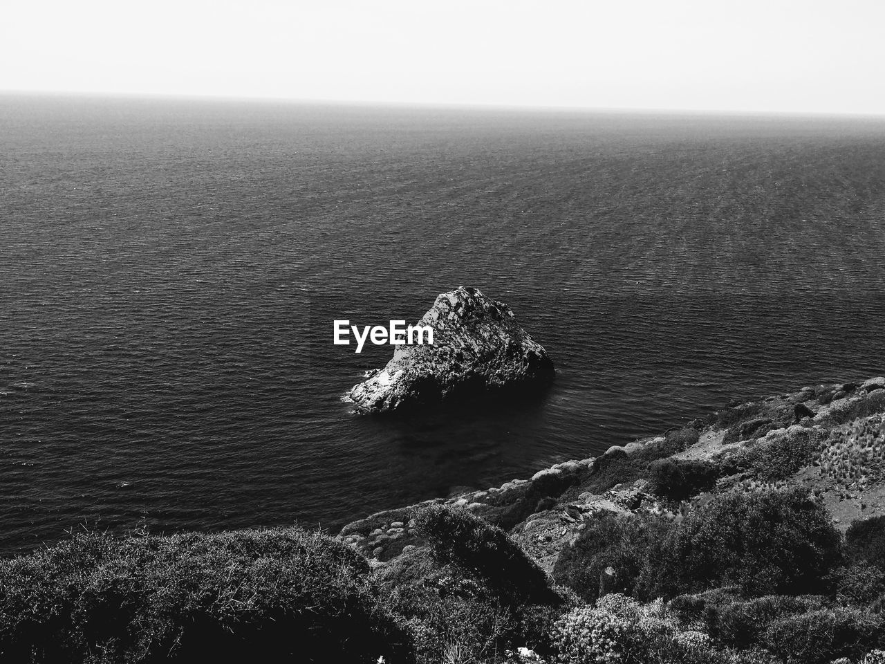 High angle view of rock in sea against sky