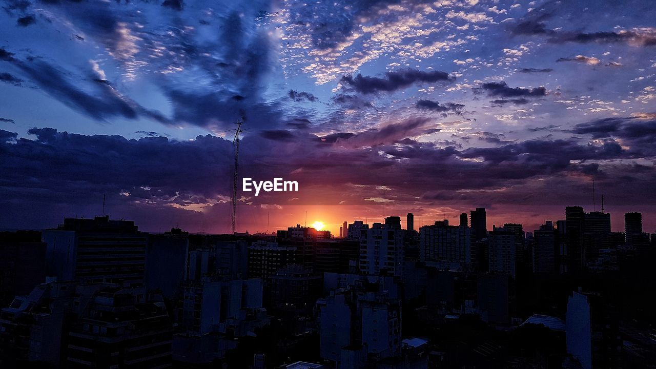 Aerial view of buildings in city against sky during sunset