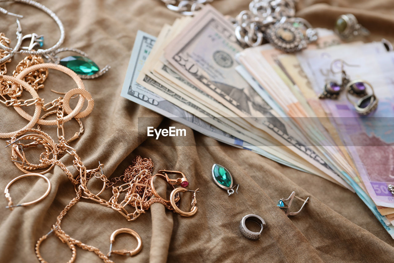 jewellery, jewelry, fashion accessory, wealth, indoors, necklace, no people, high angle view, still life, finance, large group of objects, close-up, chain, art, table, abundance, business, scissors, textile, paper currency, studio shot, currency