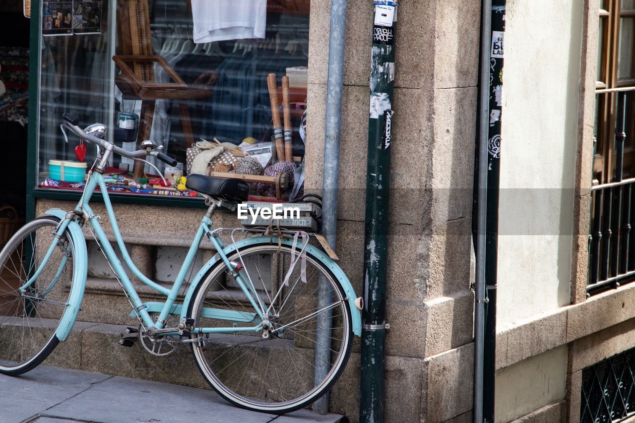 BICYCLE PARKED ON FOOTPATH BY BUILDING IN CITY