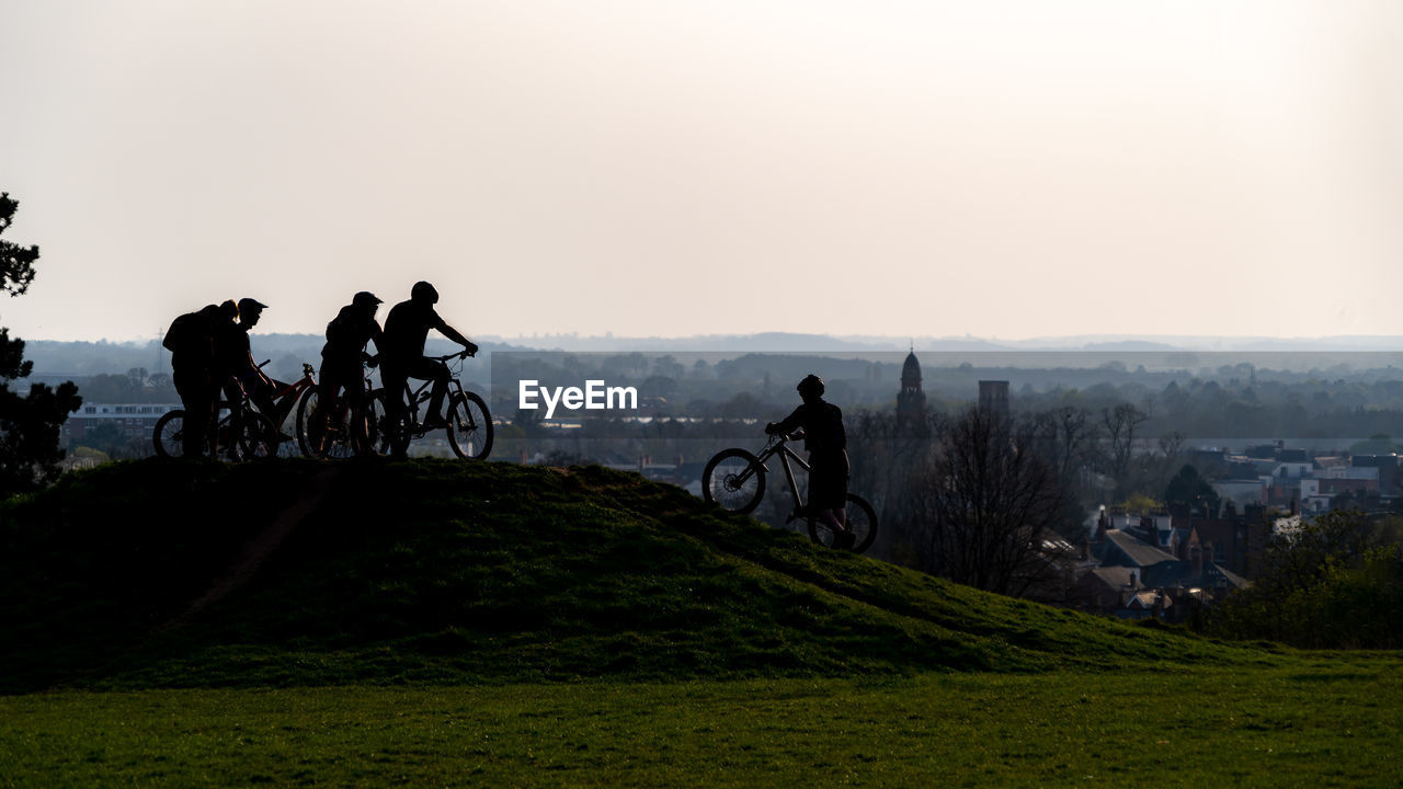 Teens meeting at bicycle riding track set against sky