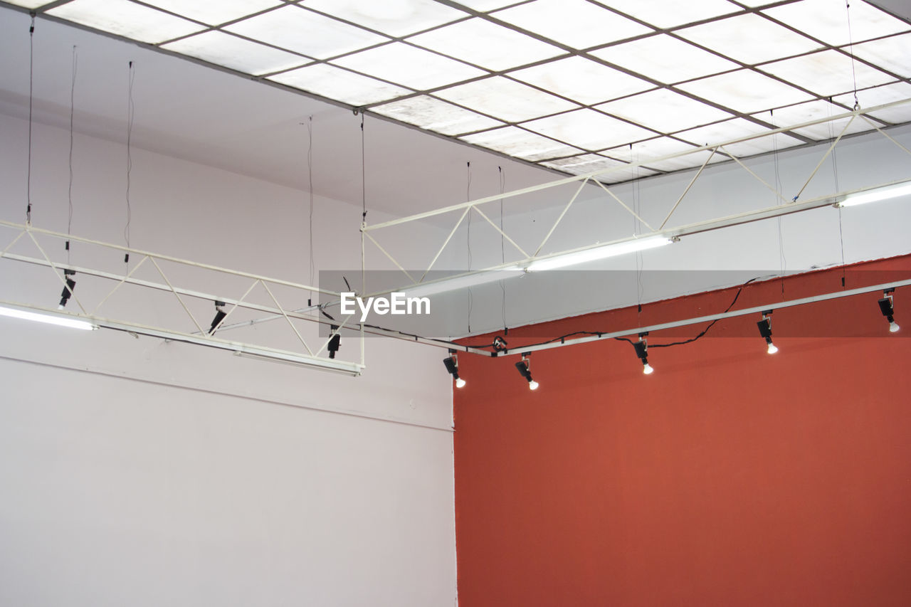 LOW ANGLE VIEW OF ILLUMINATED LIGHTS ON CEILING OF BUILDING