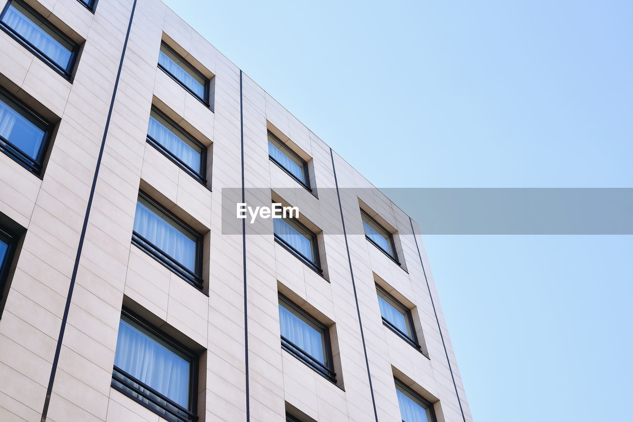 LOW ANGLE VIEW OF MODERN BUILDING AGAINST CLEAR BLUE SKY