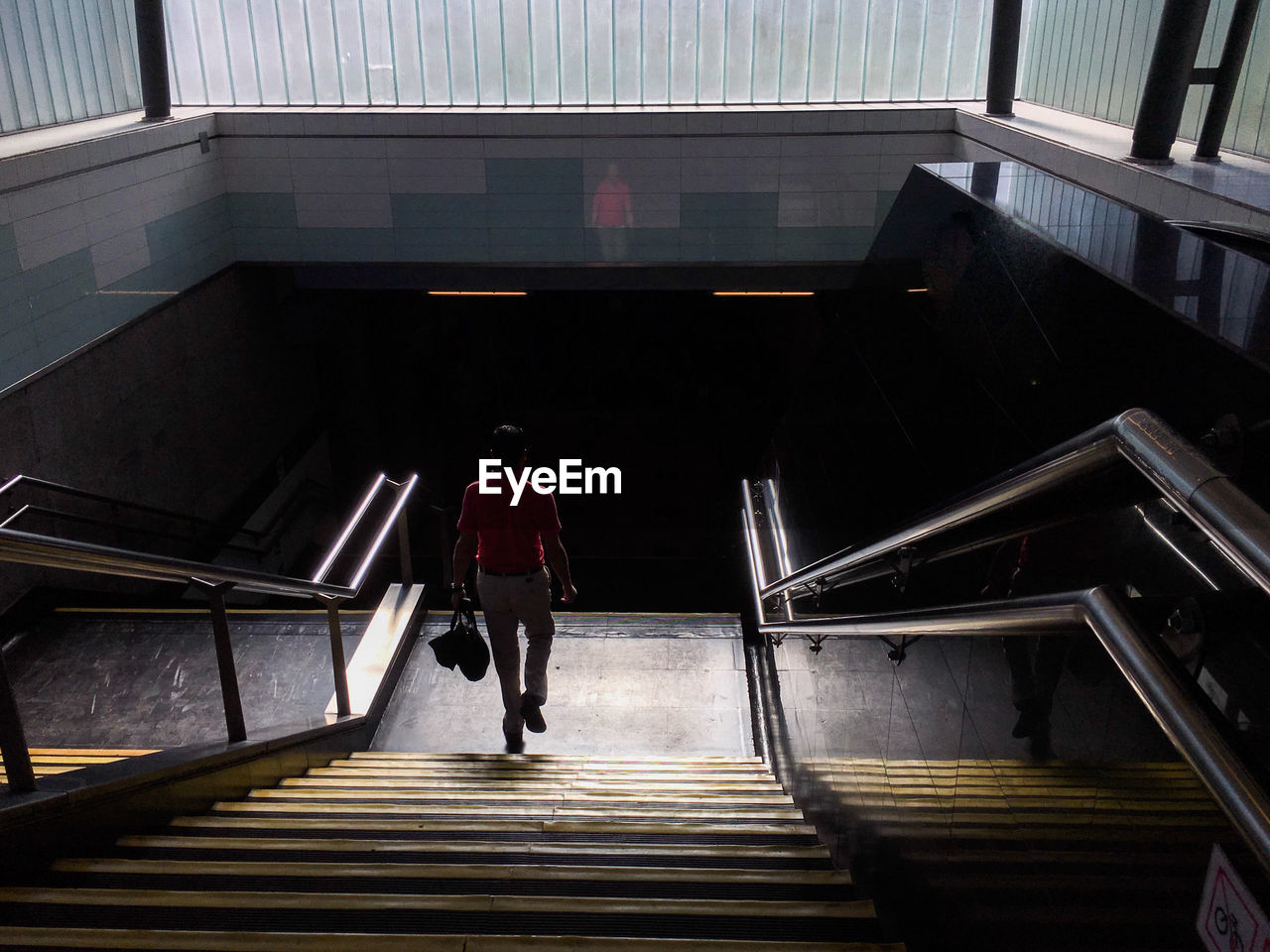 Rear view of man on subway staircase