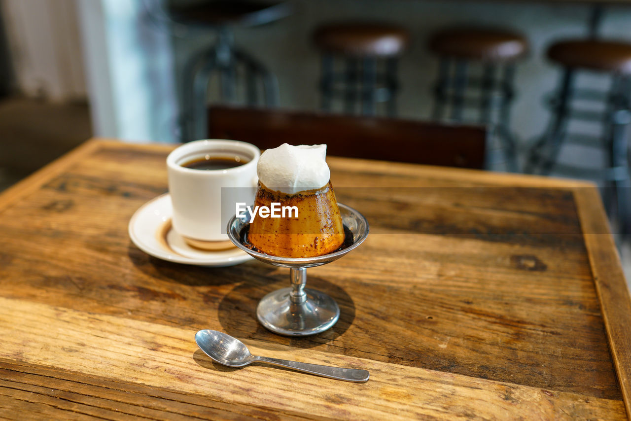 CLOSE-UP OF COFFEE CUP AND SPOON ON TABLE