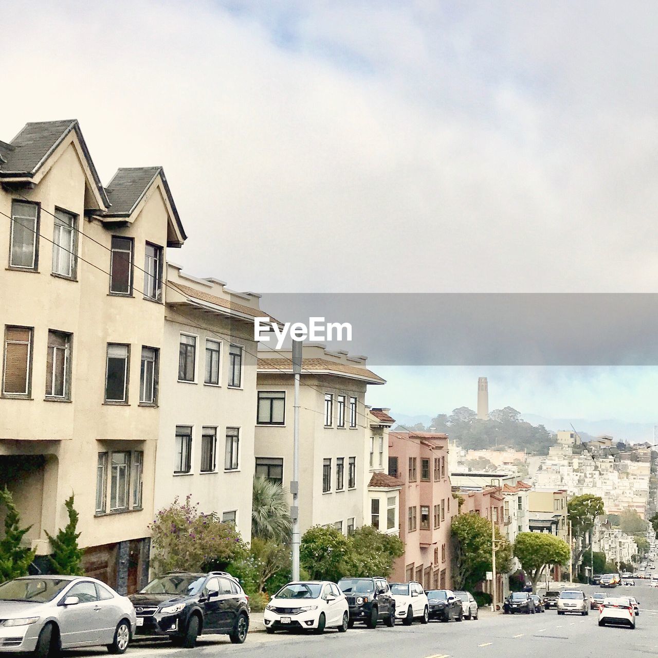 CARS ON HOUSES BY CITY AGAINST SKY