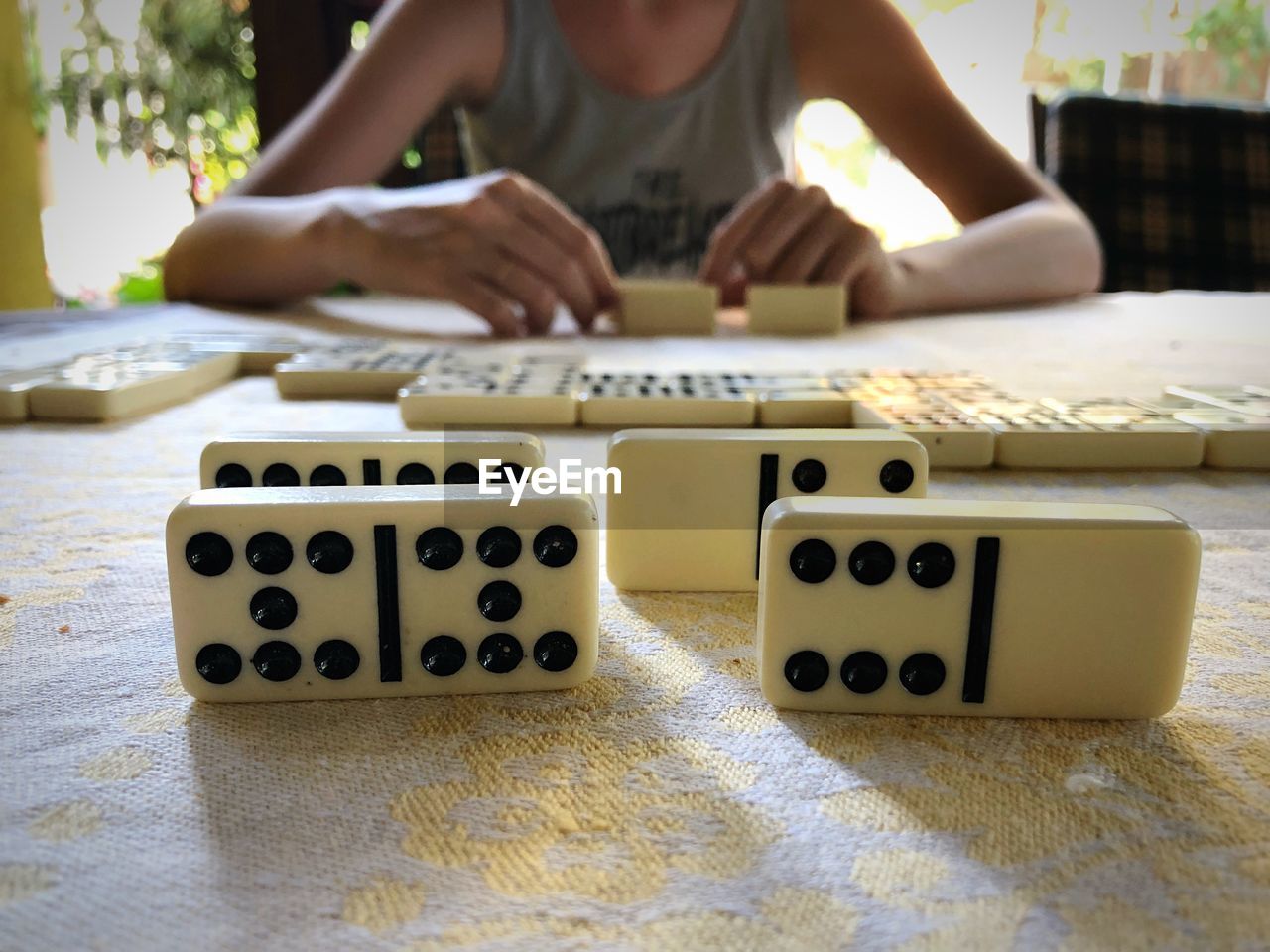Midsection of woman playing domino on table