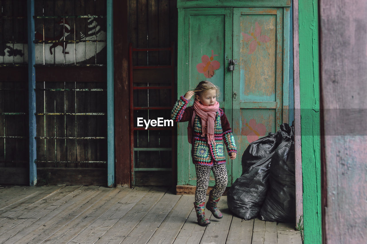 Full length of girl with open door on floor