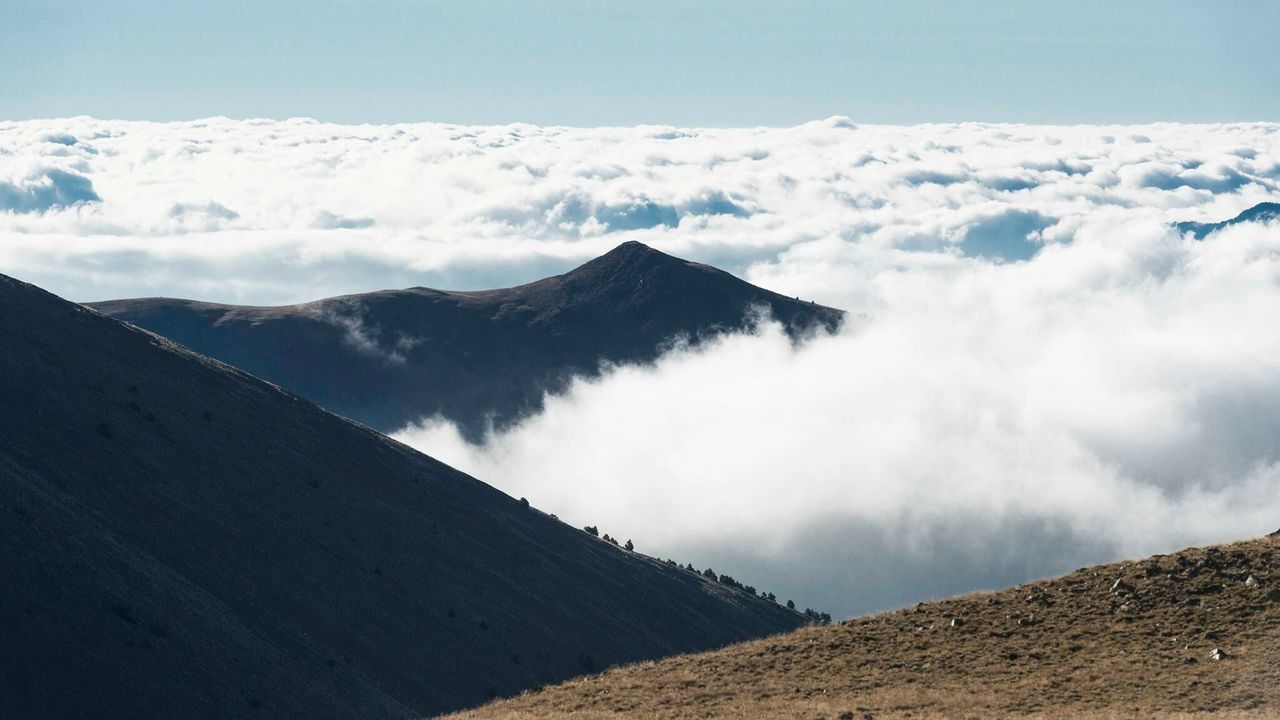 Scenic view of mountain range against cloudy sky