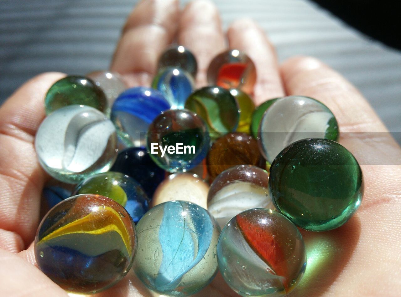 Close-up of cropped hand holding colorful marbles