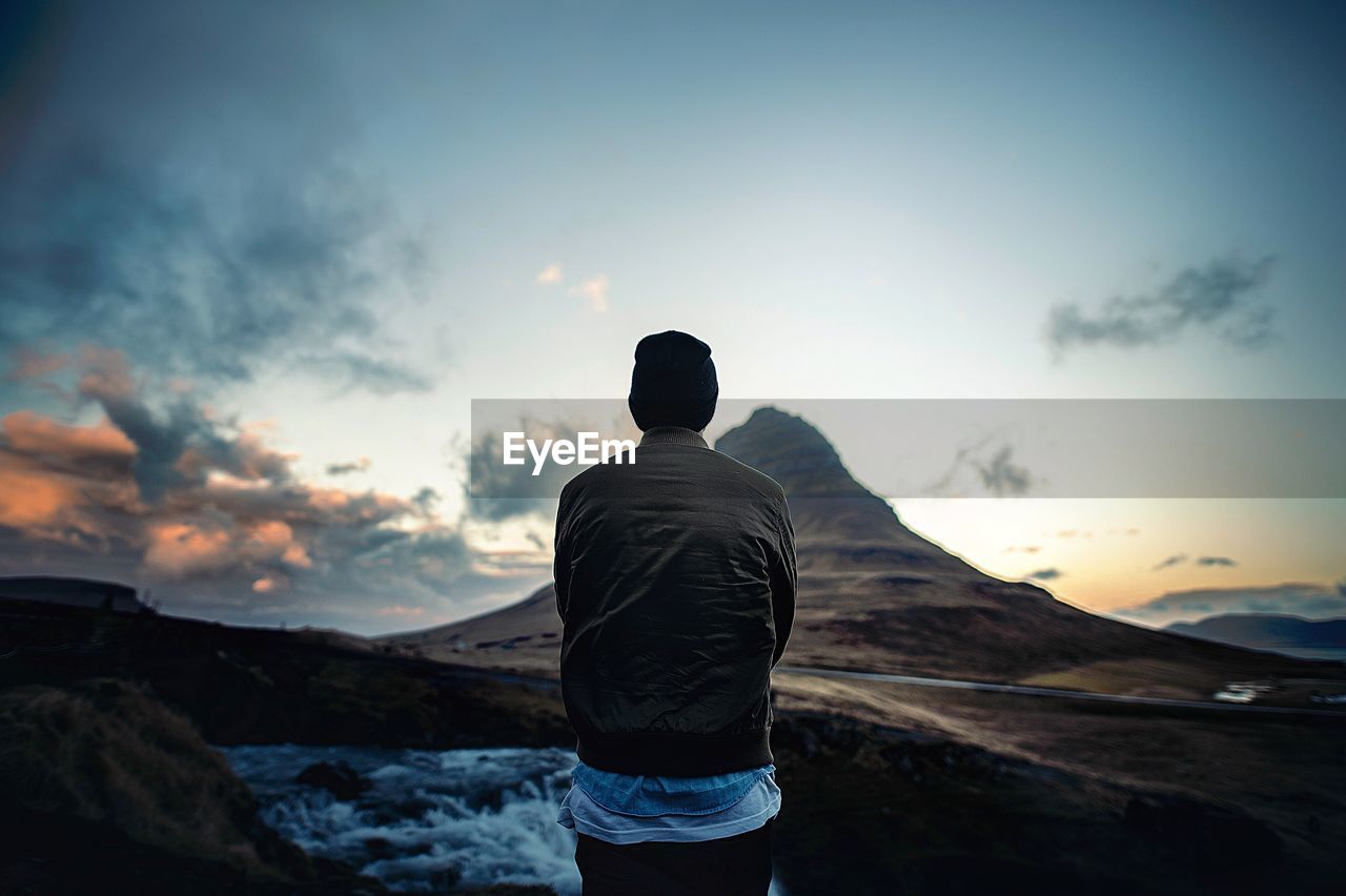 Rear view of man standing against mountain