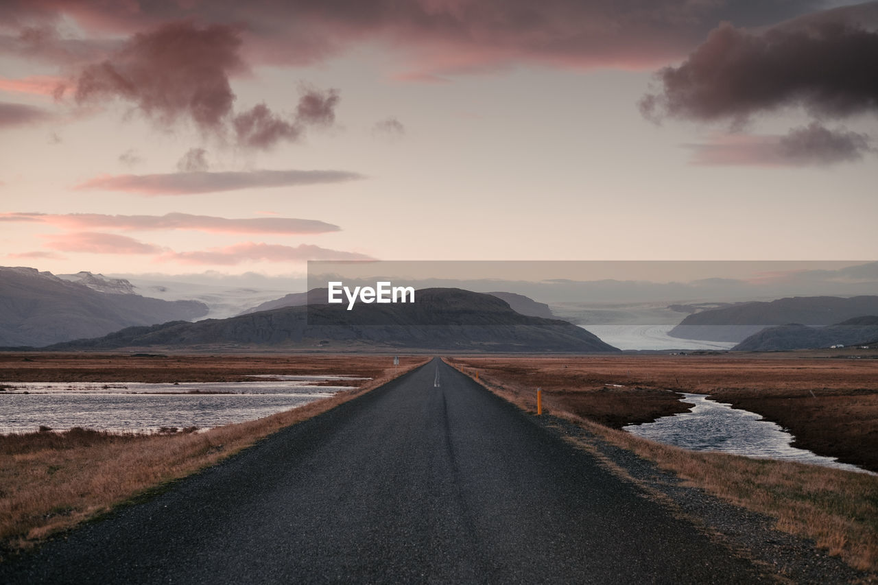 Diminishing perspective of empty road against sky during sunset