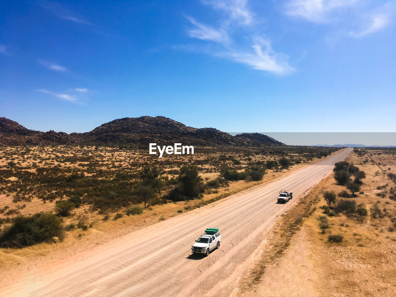 VEHICLES ON ROAD AGAINST SKY