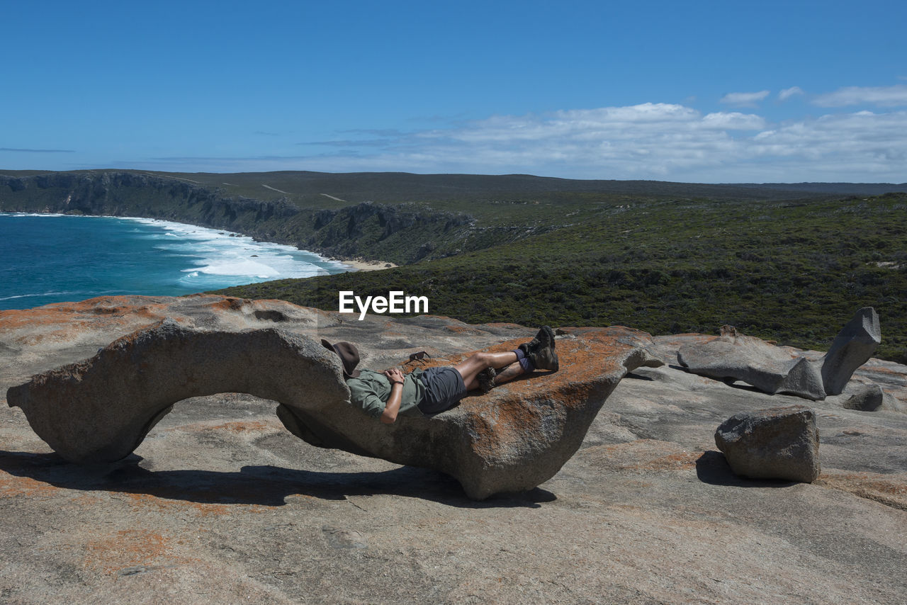 Person sleeping on a rock