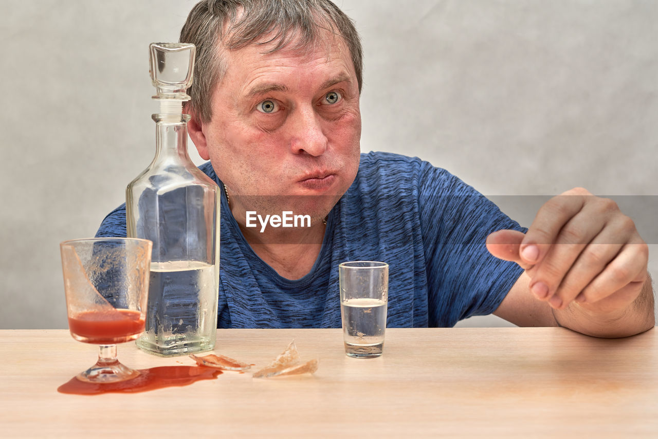 close-up of man holding glass on table